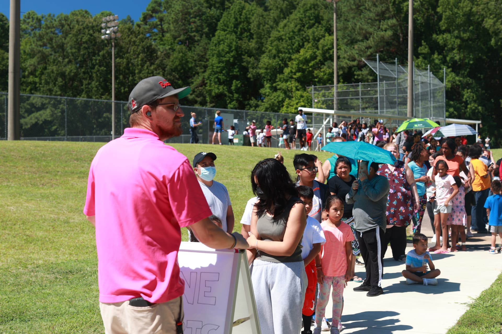 Students lined up waiting to receive backpacks filled with school supplies