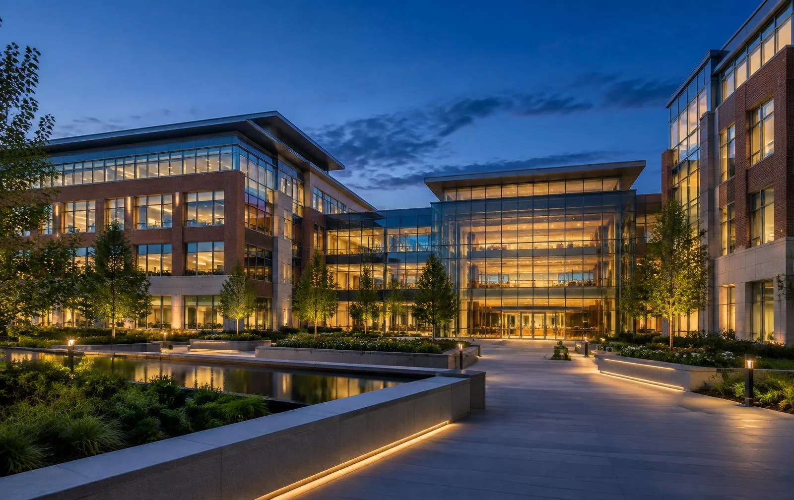Contemporary brick and glass office campus illuminated at dusk